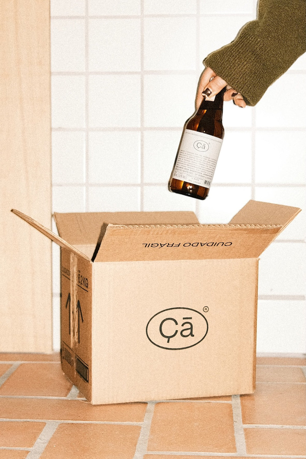 Garrafa de Çã sendo guardada na caixa de 12