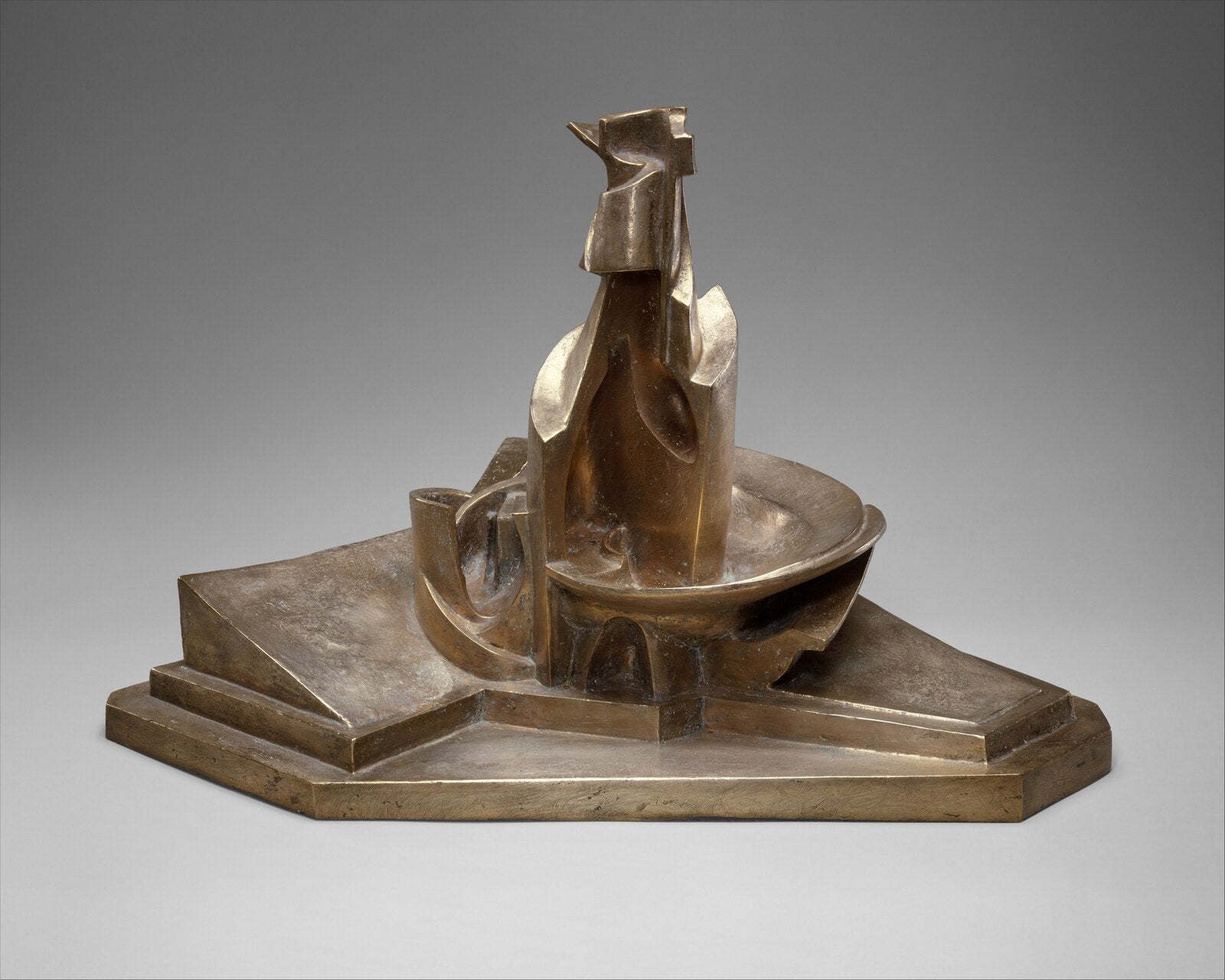 Escultura de bronze de Boccioni: uma garrafa aberta em planos sobre uma base, como se girasse no espaço.
